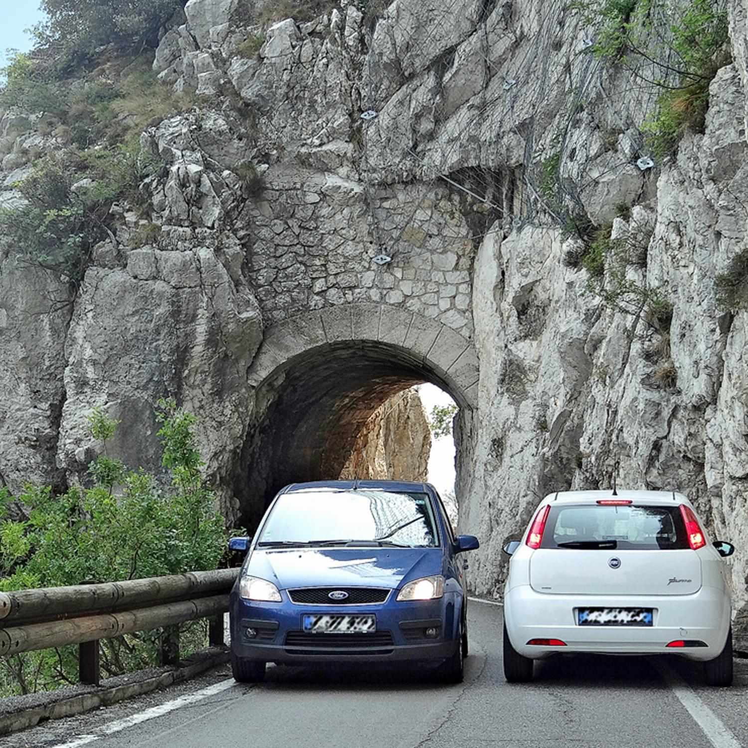 Zwei Autos stehen nebeneinander an einer Engstelle mit Felswand